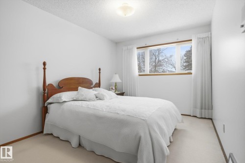 Bedroom with a textured ceiling and light colored carpet - 65 Lorne Crescent, St. Albert, AB - Indoor Photo Showing Bedroom