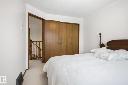 Bedroom featuring a closet, light colored carpet, and a textured ceiling - 65 Lorne Crescent, St. Albert, AB - Indoor Photo Showing Bedroom