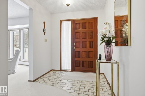 Entrance foyer with a textured ceiling and baseboards - 65 Lorne Crescent, St. Albert, AB - Indoor Photo Showing Other Room