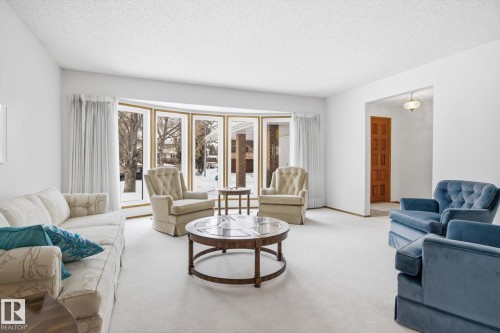 Living room with carpet floors, a textured ceiling, and healthy amount of natural light - 65 Lorne Crescent, St. Albert, AB - Indoor Photo Showing Living Room