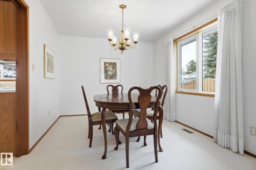 Dining space featuring light colored carpet and hanging lights - 65 Lorne Crescent, St. Albert, AB - Indoor Photo Showing Dining Room