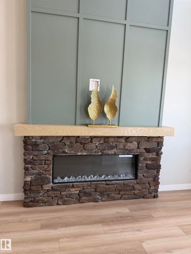 Detailed view of a fireplace and wood finished floors - 28 Harley Way, Spruce Grove, AB - Indoor Photo Showing Other Room
