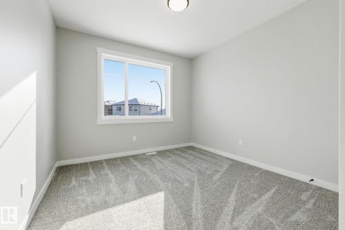 Carpeted spare room with baseboards - 28 Harley Way, Spruce Grove, AB - Indoor Photo Showing Other Room