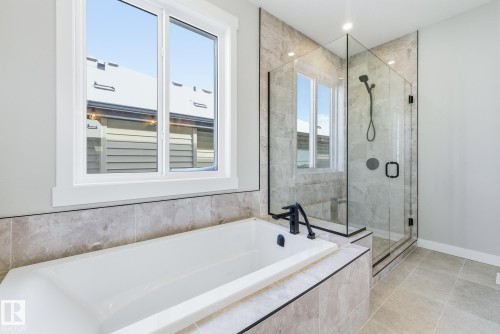 Full bathroom with a stall shower, a garden tub, and light tile patterned flooring - 28 Harley Way, Spruce Grove, AB - Indoor Photo Showing Bathroom