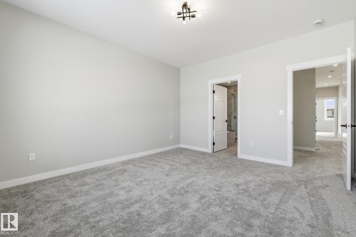 Unfurnished bedroom with light colored carpet and baseboards - 28 Harley Way, Spruce Grove, AB - Indoor Photo Showing Other Room