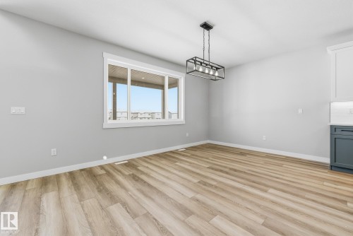 Unfurnished dining area featuring light wood-style flooring and baseboards - 28 Harley Way, Spruce Grove, AB - Indoor Photo Showing Other Room