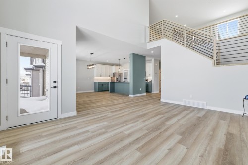 Unfurnished living room with a high ceiling, light wood-type flooring, and recessed lighting - 28 Harley Way, Spruce Grove, AB - Indoor Photo Showing Other Room