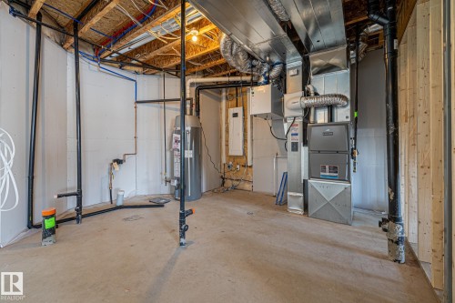 Unfinished below grade area featuring water heater, electric panel, and heating unit - 28 Harley Way, Spruce Grove, AB - Indoor Photo Showing Basement