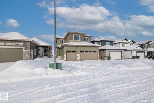 Prairie-style house with stone siding, a residential view, and a garage - 28 Harley Way, Spruce Grove, AB - Outdoor With Facade