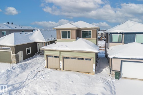 View of front of home featuring a garage, a residential view, and stone siding - 28 Harley Way, Spruce Grove, AB - Outdoor