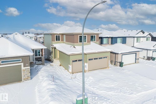 View of front facade featuring stone siding, a residential view, and a garage - 28 Harley Way, Spruce Grove, AB - Outdoor