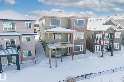 Snow covered rear of property with a residential view, a patio, and french doors - 28 Harley Way, Spruce Grove, AB - Outdoor