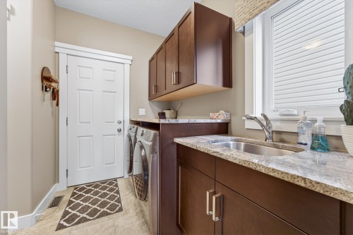 Laundry room featuring cabinet space and separate washer and dryer - 21 Dittrich, Fort Saskatchewan, AB - Indoor Photo Showing Laundry Room