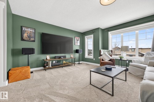 Carpeted living room with a textured ceiling and baseboards - 21 Dittrich, Fort Saskatchewan, AB - Indoor Photo Showing Living Room