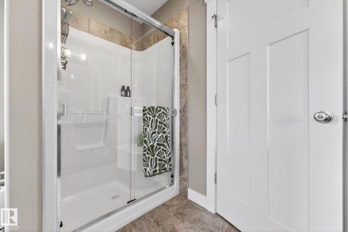 Full bath featuring a shower stall and light tile patterned flooring - 21 Dittrich, Fort Saskatchewan, AB - Indoor Photo Showing Bathroom