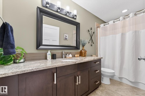 Bathroom with vanity, shower / bathtub combination with curtain, and a textured ceiling - 21 Dittrich, Fort Saskatchewan, AB - Indoor Photo Showing Bathroom