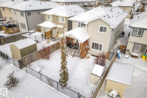 Snow covered back of property with a fenced backyard, a deck, a residential view, and a storage unit - 21 Dittrich, Fort Saskatchewan, AB - Outdoor