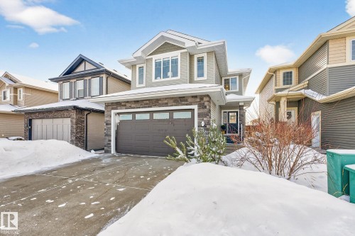 View of front of house featuring a garage, stone siding, and driveway - 21 Dittrich, Fort Saskatchewan, AB - Outdoor With Facade