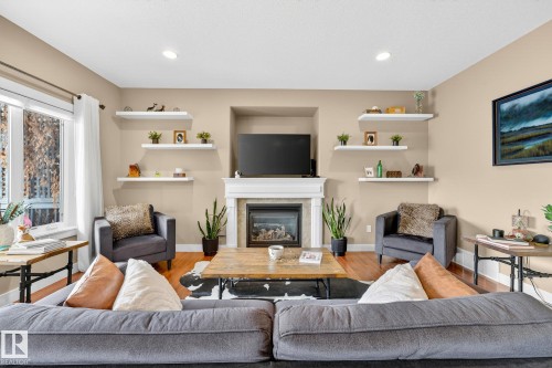 Living room featuring wood finished floors, a glass covered fireplace, and recessed lighting - 21 Dittrich, Fort Saskatchewan, AB - Indoor Photo Showing Living Room With Fireplace