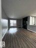 Unfurnished living room featuring a textured ceiling, dark wood-style flooring, and a tiled fireplace - 302 49 Akins Drive, St. Albert, AB  - Indoor With Fireplace 