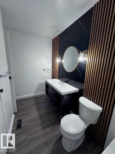 Bathroom featuring vanity, dark wood finished floors, and tile walls - 302 49 Akins Drive, St. Albert, AB - Indoor Photo Showing Bathroom