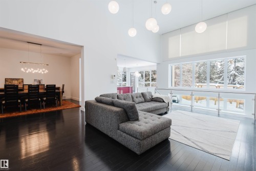 Living room featuring dark wood-type flooring, a high ceiling, and hanging lights - 6307 125 Street, Edmonton, AB - Indoor Photo Showing Living Room