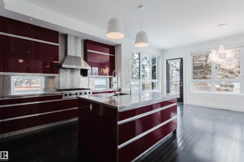 Kitchen with stainless steel countertops, modern cabinets, pendant lighting, and plenty of natural light - 6307 125 Street, Edmonton, AB - Indoor Photo Showing Kitchen