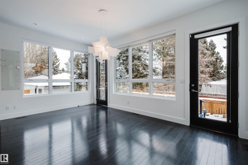 Unfurnished dining area featuring hanging lights, dark wood finished floors, and electric panel - 6307 125 Street, Edmonton, AB - Indoor
