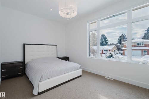 Carpeted bedroom featuring baseboards and a chandelier - 6307 125 Street, Edmonton, AB - Indoor Photo Showing Bedroom