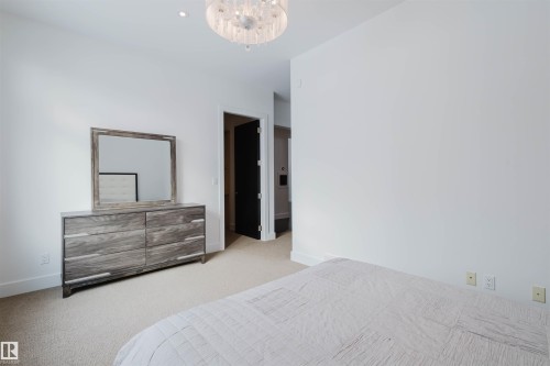 Carpeted bedroom with baseboards and suspended lighting - 6307 125 Street, Edmonton, AB - Indoor Photo Showing Bedroom