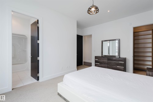 Bedroom with light colored carpet, ensuite bath, recessed lighting, and light tile patterned floors - 6307 125 Street, Edmonton, AB - Indoor Photo Showing Bedroom