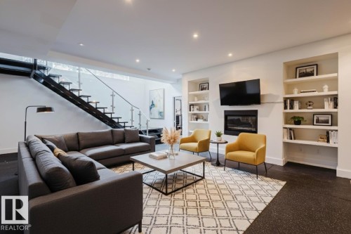 Living area featuring built in features, a glass covered fireplace, and recessed lighting - 6307 125 Street, Edmonton, AB - Indoor Photo Showing Living Room With Fireplace