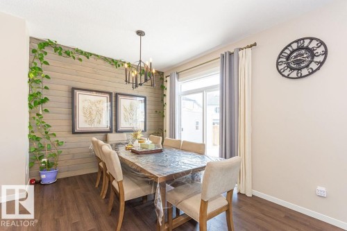 Dining space featuring dark wood-style flooring, a chandelier, and wood walls - 3128 13 Avenue, Edmonton, AB - Indoor Photo Showing Dining Room
