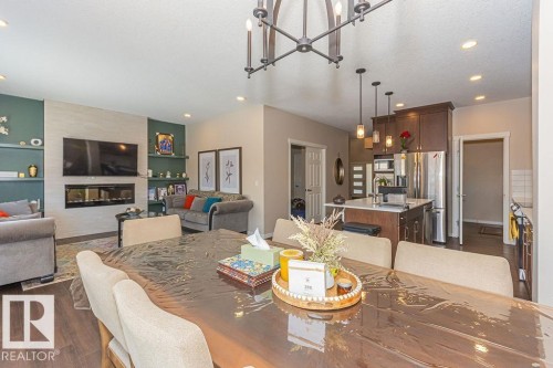 Dining space featuring dark wood-style flooring, hanging lights, and a fireplace - 3128 13 Avenue, Edmonton, AB - Indoor Photo Showing Dining Room