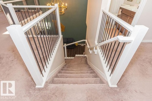 Staircase with carpet floors and hanging lights - 3128 13 Avenue, Edmonton, AB - Indoor Photo Showing Other Room