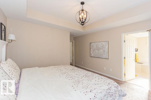 Carpeted bedroom with a raised ceiling and suspended lighting - 3128 13 Avenue, Edmonton, AB - Indoor Photo Showing Bedroom