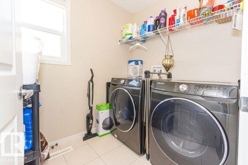 Laundry area featuring light tile patterned floors and washer and dryer - 3128 13 Avenue, Edmonton, AB - Indoor Photo Showing Laundry Room