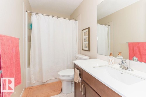 Bathroom with vanity, shower / bath combo with shower curtain, and light tile patterned floors - 3128 13 Avenue, Edmonton, AB - Indoor Photo Showing Bathroom