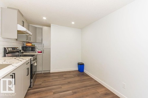 Kitchen with stainless steel appliances, dark wood-style floors, gray cabinets, recessed lighting, and decorative backsplash - 3128 13 Avenue, Edmonton, AB - Indoor Photo Showing Kitchen