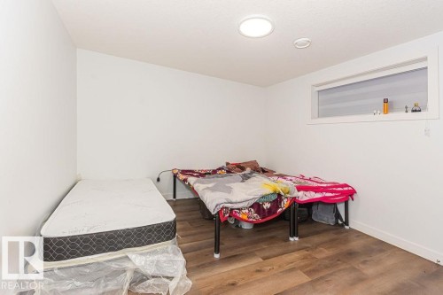 Bedroom with wood finished floors and baseboards - 3128 13 Avenue, Edmonton, AB - Indoor Photo Showing Other Room