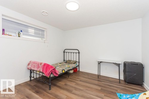 Bedroom with dark wood-style floors and baseboards - 3128 13 Avenue, Edmonton, AB - Indoor Photo Showing Other Room