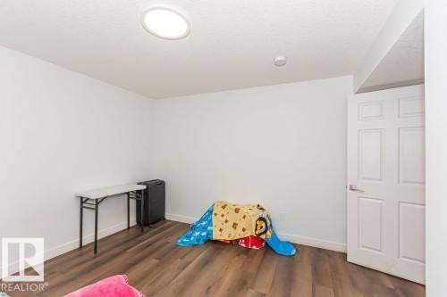 Game room with dark wood-style flooring and a textured ceiling - 3128 13 Avenue, Edmonton, AB - Indoor