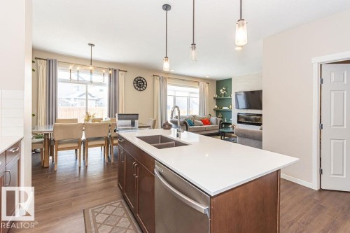 Kitchen featuring stainless steel dishwasher, hanging light fixtures, open floor plan, and dark wood-style flooring - 3128 13 Avenue, Edmonton, AB - Indoor Photo Showing Kitchen With Double Sink With Upgraded Kitchen