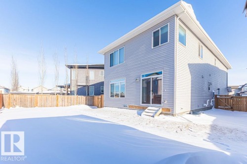 Snow covered back of property featuring a fenced backyard, entry steps, and a gate - 3128 13 Avenue, Edmonton, AB - Outdoor