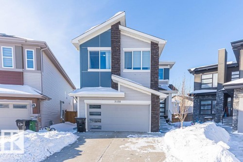 Contemporary house featuring an attached garage, driveway, and stone siding - 3128 13 Avenue, Edmonton, AB - Outdoor With Facade