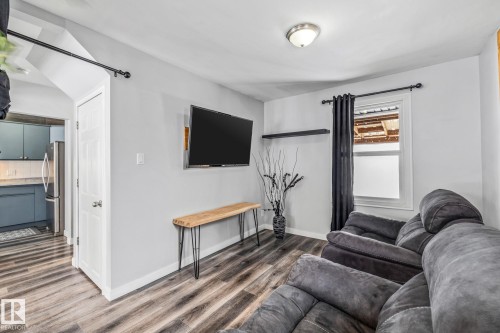 Living area featuring dark wood-type flooring and baseboards - 5911 119 Avenue, Edmonton, AB - Indoor Photo Showing Living Room