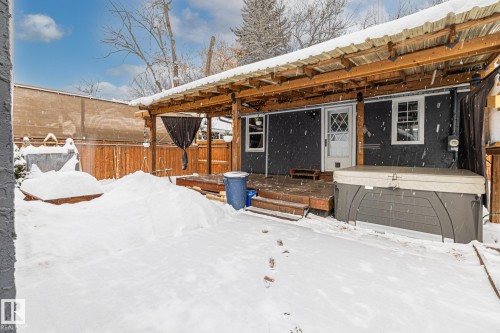 Snow covered house with a fenced backyard and a wooden deck - 5911 119 Avenue, Edmonton, AB - Outdoor