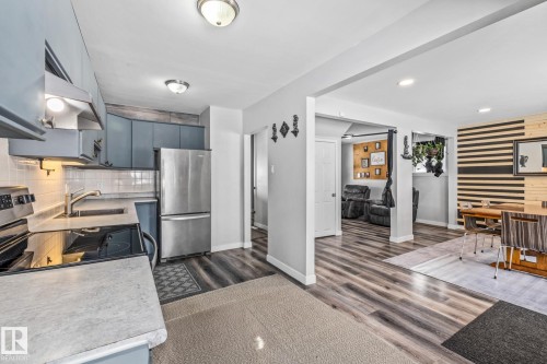 Kitchen with stainless steel appliances, light countertops, extractor fan, dark wood finished floors, and recessed lighting - 5911 119 Avenue, Edmonton, AB - Indoor Photo Showing Kitchen