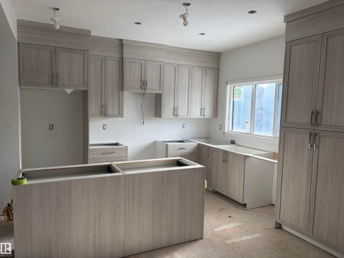 Kitchen with a center island, a textured ceiling, and light flooring - 8923 Elves Loop, Edmonton, AB - Indoor Photo Showing Kitchen