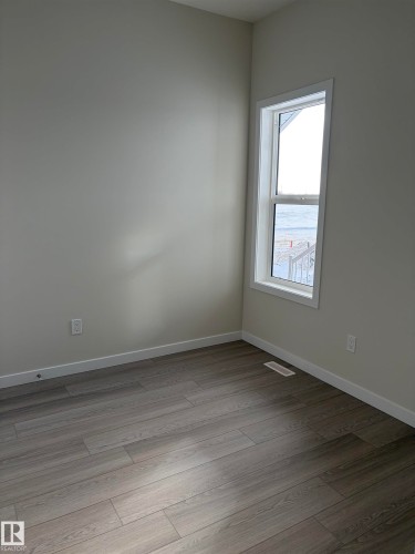 Spare room featuring baseboards and light wood-style flooring - 5756 Hawthorn Common, Edmonton, AB - Indoor Photo Showing Other Room